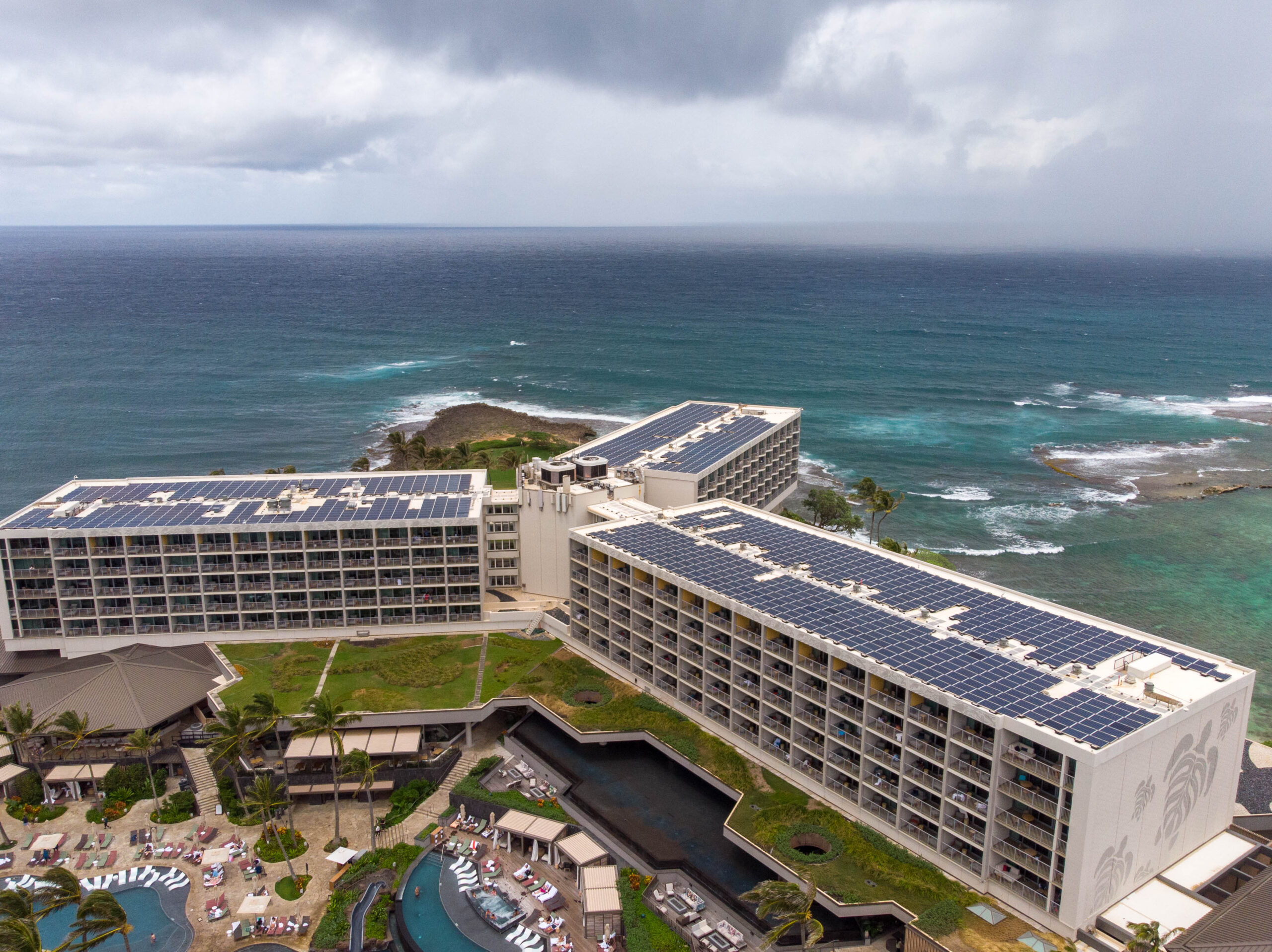 Oceanside resort featuring solar panels installed by Adon Renewables on the roof.
